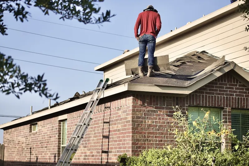 Professional roofer working on a residential roof in Orchard Breeze